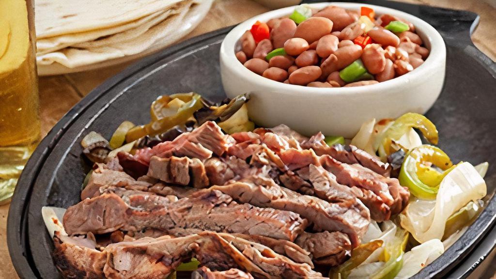 Steak Fajitas · Fire-grilled, marinated steak* served with grilled onions and peppers, Mexican rice, charro beans, homemade guacamole, sour cream, cheese and pico de gallo.
