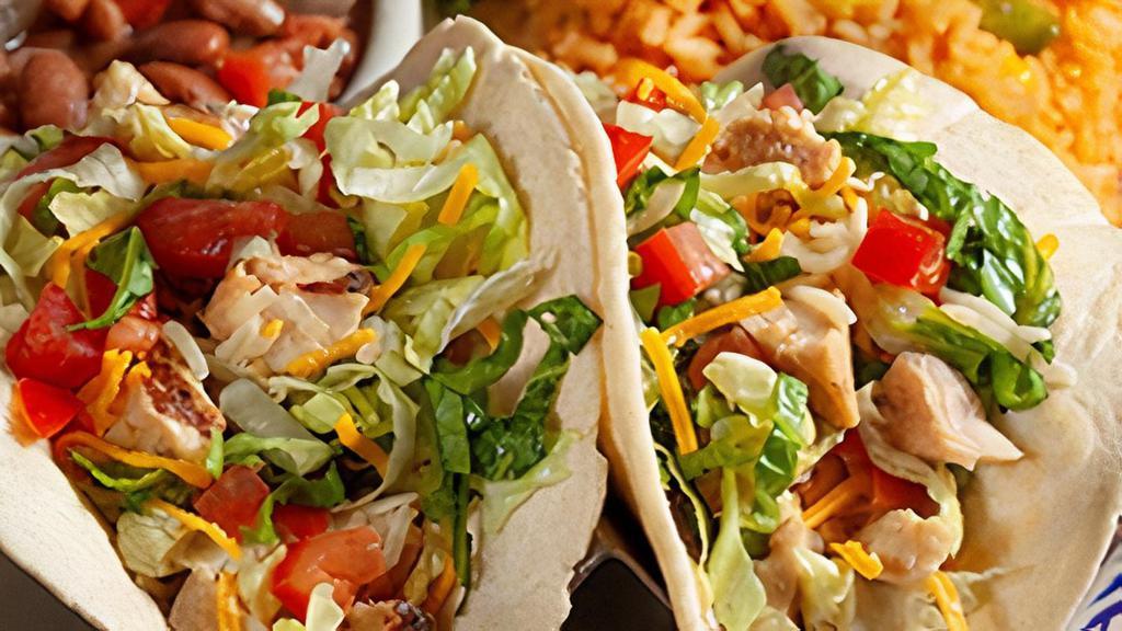 Fajita Chicken Tacos · Two soft, handmade flour tortilla fajita chicken tacos with lettuce, diced tomatoes and blended cheeses.  Served with charro beans and Mexican rice.