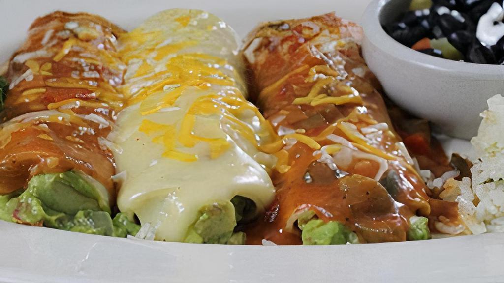 Vegetarian Enchiladas · Three avocado enchiladas topped with your choice of ranchera sauce or chile con queso. Served with cilantro lime rice and black beans.