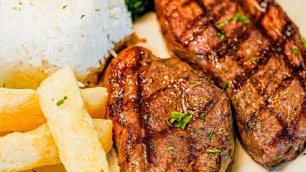 Punta De Anca · Grilled cap of sirloin steak picanha (12oz). Served with white rice, fried yuca, garlic mojo, and seasonal vegetables.