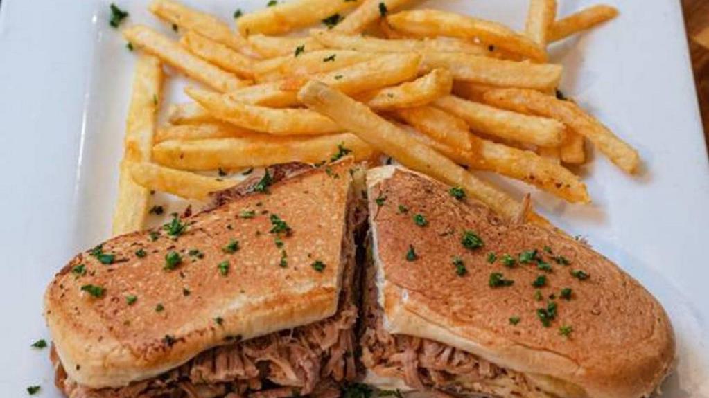 El Cubano Sandwich · A classic Cuban favorite. Slow roasted pork, sliced ham, Swiss cheese, pickle, mustard, and mayonnaise pressed on fresh Cuban bread. Served with fries and salad or small soup.