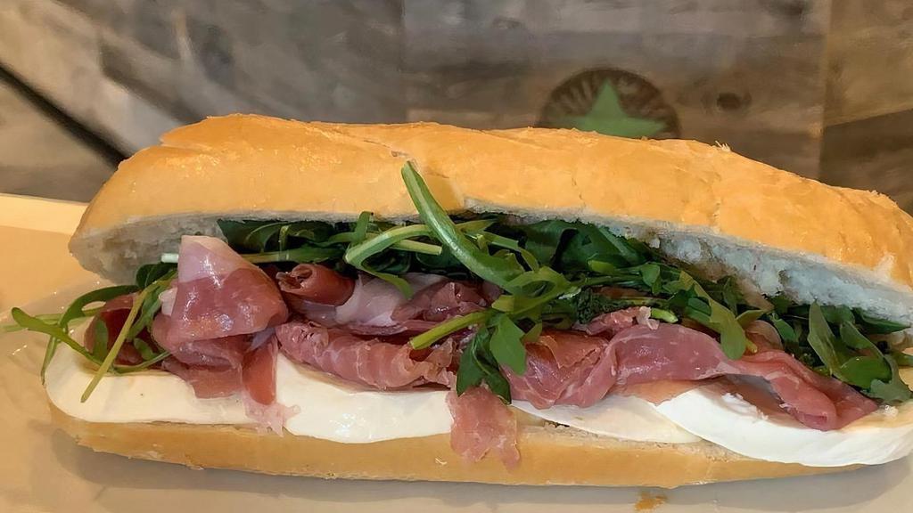 Prosciutto & Mozz · Thinly sliced prosciutto topped with fresh buffalo mozzarella and arugula drizzled with pure olive oil and balsamic glaze served on a freshly baked baguette.