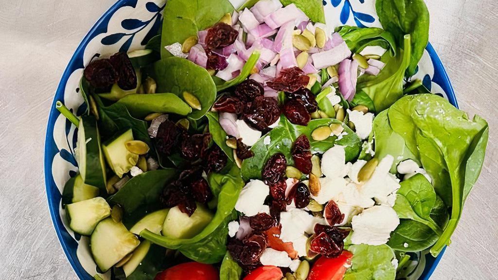 Spinach Salad · Organic baby spinach, diced cucumbers, cherry tomatoes, chopped red onion, dried cranberries, goat cheese crumble, & pumpkin seeds