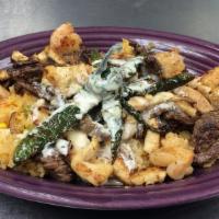 Tres Amigos · Chicken, steak, and shrimp, on a bed of rice, smothered with cheese sauce. Garnished with a ...