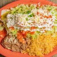Super Burrito · Steak or chicken topped with red or green sauce, lettuce, tomatoes and sour cream. Served wi...