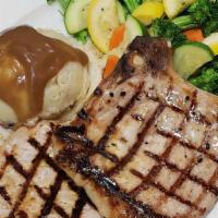 Grilled Pork Chops · 2 seasoned and grilled 8 oz centercut pork chops served with mashed potatoes and mixed veget...