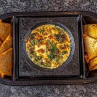 Spinach Artichoke Dip · A blend of fresh spinach and artichoke hearts, baked with melting cheese in our volcanic bow...