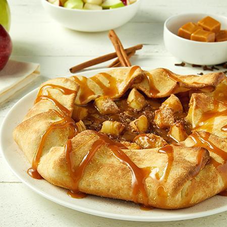 Salty Caramel Apple Pie · Tender crust filled with sweetened cinnamon spread, fresh, crisp apples, and oat streusel topping. Oven baked and drizzled with salty caramel and cut into 8 pieces. Serves 4.