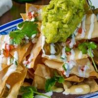 Nachos · Large Platter of Crispy Tortilla Chips, Cheese Sauce, Pickled Jalapenos, Pico de Gallo, Refr...