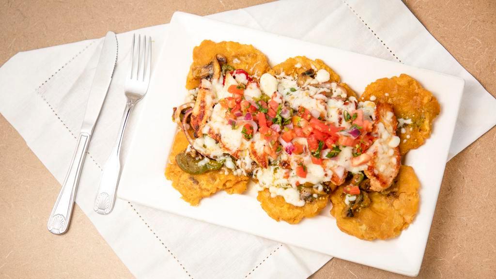 Chicken Tostones · Fried green plantains, topped with grilled chicken, peppers, onions, mushrooms, green tomatillo sauce, melted cheese, and pico de gallo.