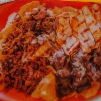 Meat Lovers Nachos · Nachos topped with cheese sauce, steak, chorizo, carnitas, and grilled chicken