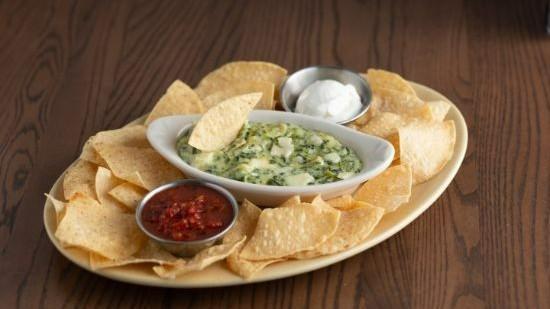 Spinach Artichoke Dip · A creamy blend of spinach, artichoke hearts and Italian cheeses. Served with tortilla chips, salsa and sour cream.