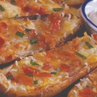 Potato Skins · Six crispy potato skins covered in three cheeses, topped with bacon and chives. Served with ...