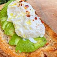 Avo + Egg · Two poached eggs, chili flakes over sliced avocado on multigrain loaf.