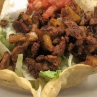 Taco Salad · A tortilla shell filled with shredded chicken or ground beef in a bed of lettuce topped with...