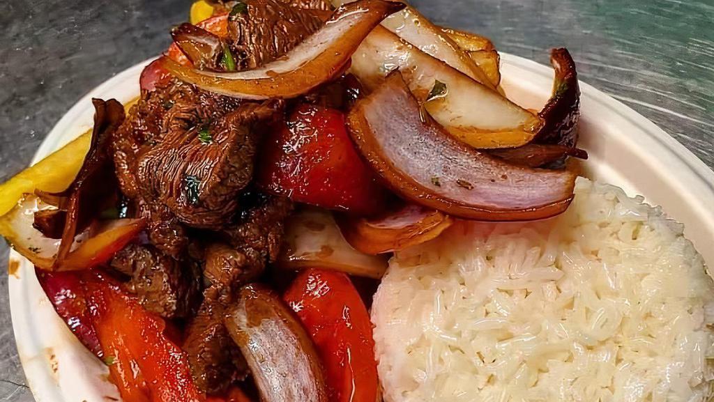 Lomo Saltado · 5 oz of Tenderloin cubes flambeed with red onion, tomatoes, and cilantro. Served with crispy French fries and white rice.