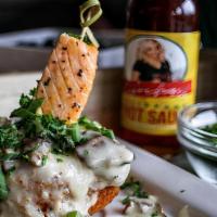 Salmon Grit Cake · Salmon bite over decadent fried golden brown grit cake topped with jalapeno, cheese and mush...
