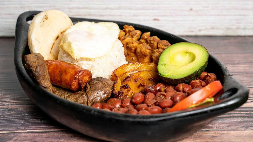 Bandeja Paisa · Red beans, rice, fried pork belly, sausage, grilled steak, fried egg sunny up, avocado, sweet plantains, and small arepa.