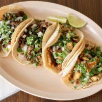 Crispy Tacos / Tacos Dorados · Four crispy tortillas filled with chicken or steak. Topped with refried beans, crema, lettuc...