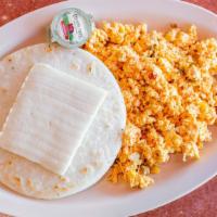 Huevos Perico Con Arepa Y Queso / Colombian Scrambled Egg With Arepa And Cheese · Huevos revueltos con torta de maíz y queso. / Scrambled eggs with corn cake and cheese.