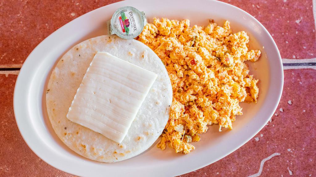 Huevos Perico Con Arepa Y Queso / Colombian Scrambled Egg With Arepa And Cheese · Huevos revueltos con torta de maíz y queso. / Scrambled eggs with corn cake and cheese.
