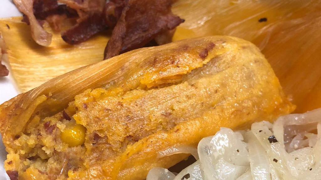 Tamal Preparado · Tamale served on a plate with ham, Swiss cheese, pork, and pickles.