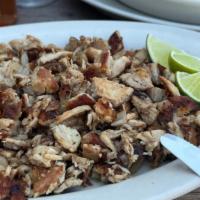 Lechon Asado · Roasted pork garnished with onions.