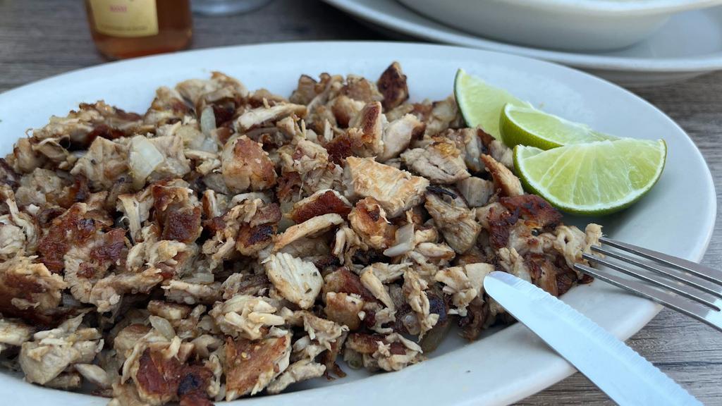 Lechon Asado · Roasted pork garnished with onions.