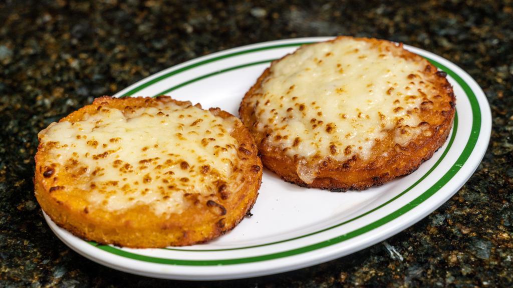 Arepa De Chocolo / Sweet Corn Arepa · Arepa de chocolo servida con manteca y queso blanco. / Sweet corn arepa served with butter and white cheese.