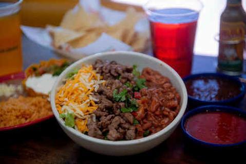 Bowls · Your choice of chicken or steak with rice, whole pinto beans, pico de gallo and your choice of tomatillo or red salsa. Served with green leafy lettuce and a four blend Mexican cheese.