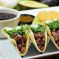 Tacos De Asada · Marinated steak topped with onions and cilantro. Served with rice and beans.