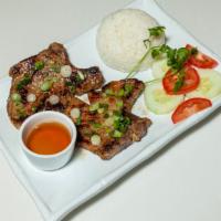 Pork Chops · Marinated in garlic shallot sauce, served with slaw, jasmine rice, and a side of chicken bro...