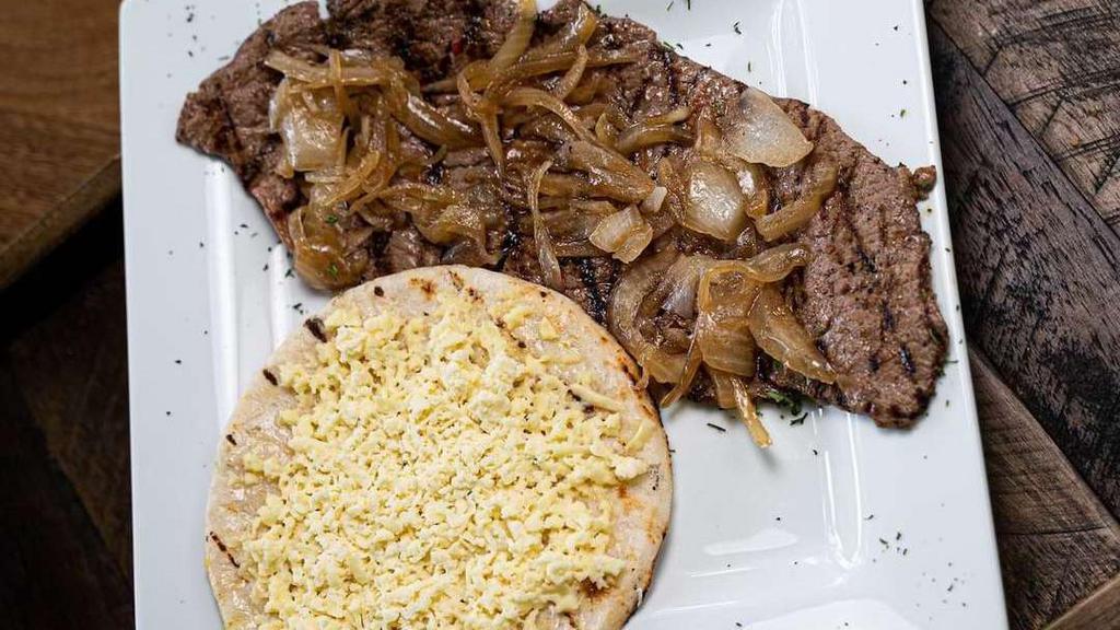 Carne Asada Breakfast · Grilled steak topped with sauteed onions. Served with arepa paisa topped with white cheese.