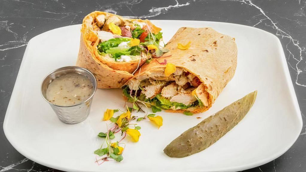 Mediterranean Grilled Chicken Wrap · Grilled chicken breast sliced romaine lettuce, tomato, kalamata olive, feta cheese, and hummus with Greek dressing in a herbed wrap.