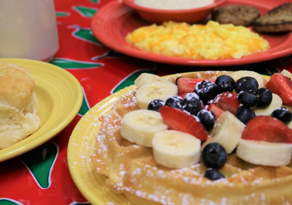 Fl Sunshine Waffle Breakfast · Two eggs, choice of breakfast meat, choice of side, a golden Belgian waffle topped with fresh bananas, strawberries, blueberries and powdered sugar served with a fluffy flying biscuit and cranberry apple butter.