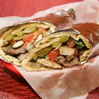 Beef Shawarma Sandwich · Thin-cut marinated beef in pita bread with onions, parsley, and sumac. Topped with tahini.