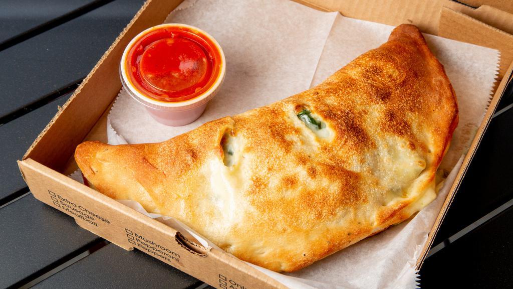 Spinach Calzone (Large) · Shredded mozzarella, ricotta, spinach, served with tomato sauce.