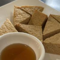 Tofu Triangle · Tofu fried golden brown. Served with sweet and sour sauce and topped with ground peanut.