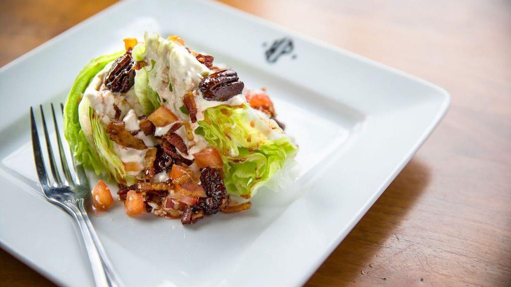 Hyde Park Wedge · Smoked bacon, candied pecans, heirloom tomatoes, blue cheese dressing, port wine drizzle