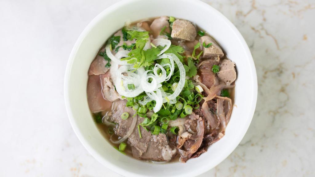House Pho · Rare eyeround steak, soft tendon, tripe, meatball and brisket. A traditional Vietnamese rice noodle soup dish consisting off beef broth topped with green and white onions. Served with a side of herbs and vegetables.