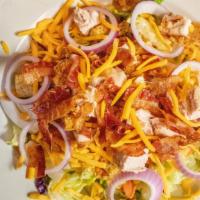 Chicken Club Salad · Chopped chicken tenders on a bed of crisp iceberg and romaine with crispy bacon pieces, purp...