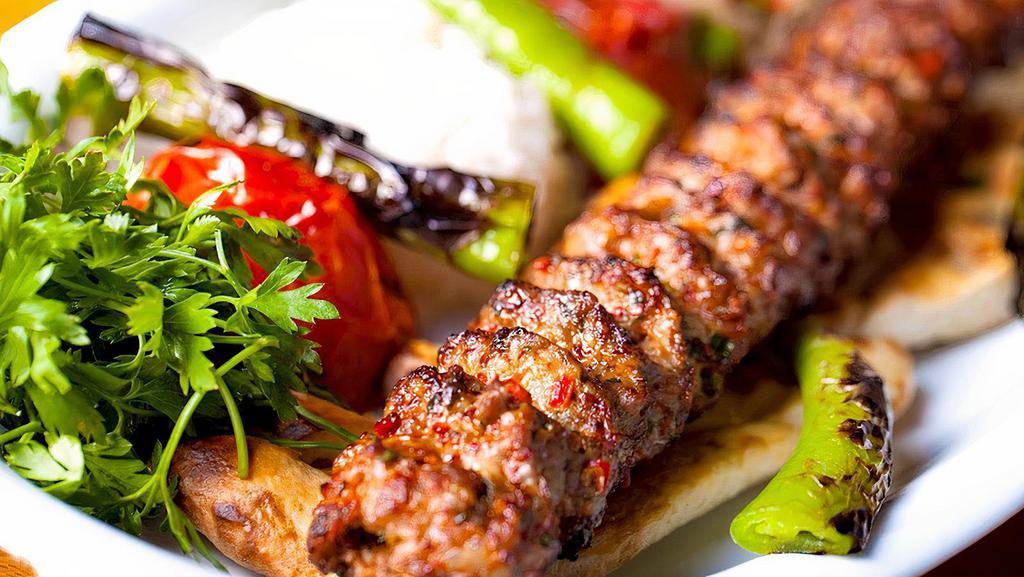 Adana Kebab Plate · Freshly ground lamb and beef flavored with red bell peppers & light hot peppers, sprinkled with seasonings and expertly chargrilled on a skewer. Serve  with rice and salad