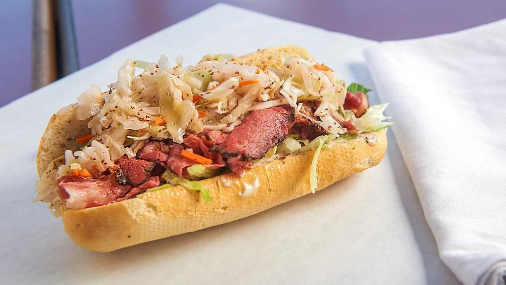 The Super Dave · Pastrami, corned beef, mayo, lettuce, mustard, tomato, topped with a generous portion of Dave’s coleslaw, herbs, and Dave’s cosmic sauce.