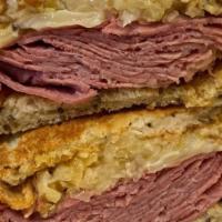 Reuben Sandwich · Corned beef and melted swiss, fresh sauerkraut and Russian dressing grilled on new york rye ...