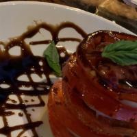 Caprese Stack · Fresh mozzarella and tomatoes piled high with basil leaves and balsamic reduction.