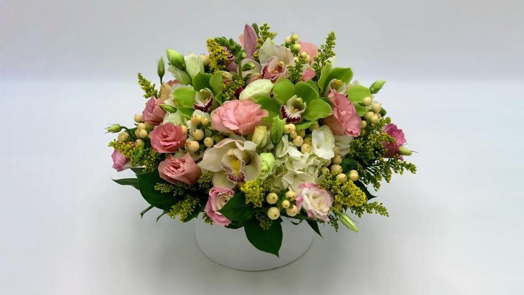 Garden Blooms · A mixed and elegant bouquet designed with delicate flowers as Lisianthus blooming over white hydrangeas and our unique Cymbidiums Orchids accented with Solidago and Yellow Hypericum.