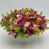 Tropical Garden · A combination of purple mokaras orchids with white roses, orange king protea and solidago, a...