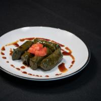 Dolmatos · Vegetarian. Grape leaves stuffed with rice and herbs topped with pomegranate sauce.