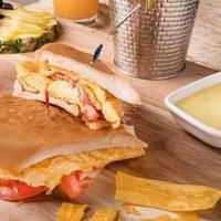 Breakfast Sandwich · 2 eggs any style with a choice of ham or bacon on a toasted cuban bread served with café con...
