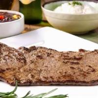 Palomilla · Traditional style steak, cooked on the grill, garnished with chopped onions and parsley.
